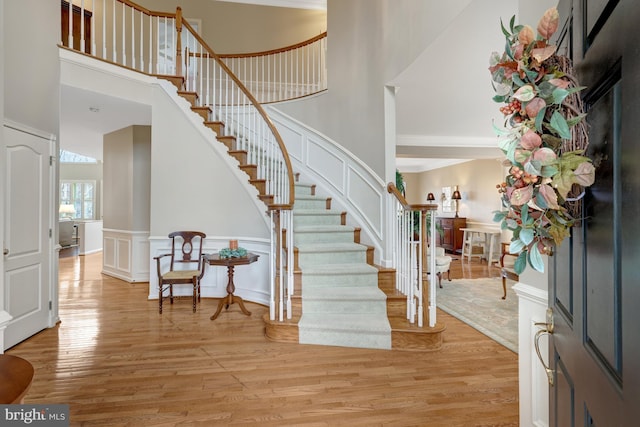 entryway featuring a high ceiling, light wood-style flooring, and a decorative wall