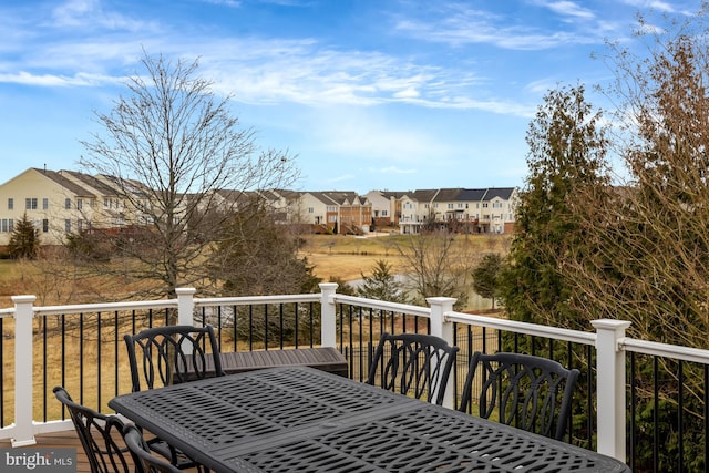 wooden deck with a residential view and outdoor dining space