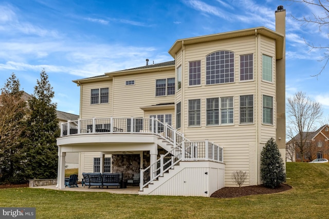 back of property with stairway, a patio area, a lawn, and a chimney