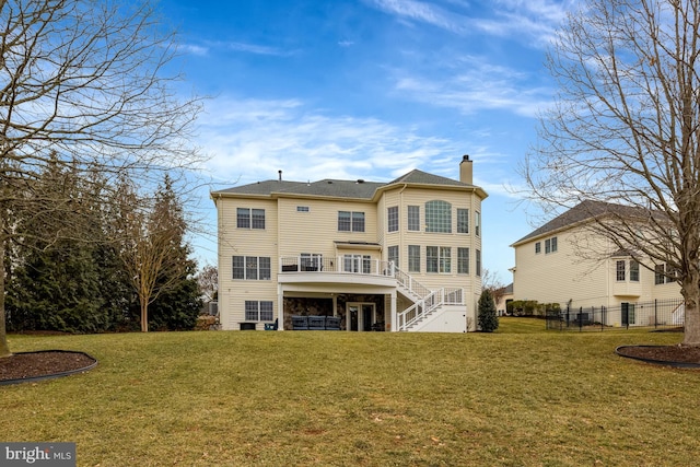 back of property with stairway, a chimney, a yard, and fence