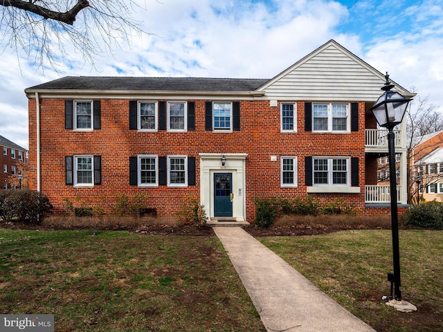 view of front of home with brick siding and a front lawn