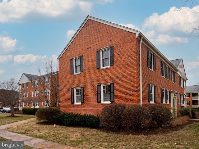 view of home's exterior with a lawn and brick siding