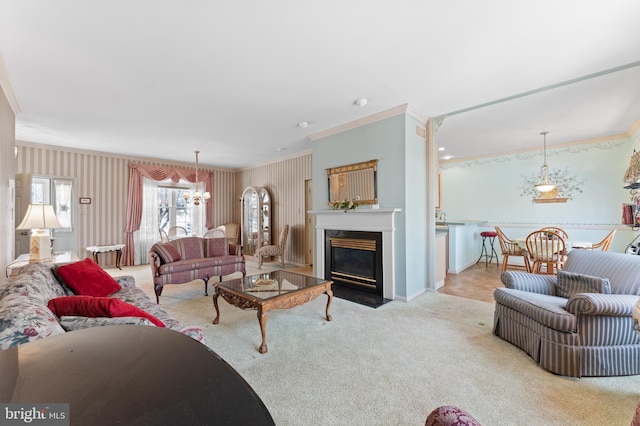 living area featuring a chandelier, carpet flooring, ornamental molding, and a premium fireplace