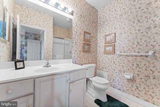 bathroom with tile patterned flooring, toilet, and wallpapered walls