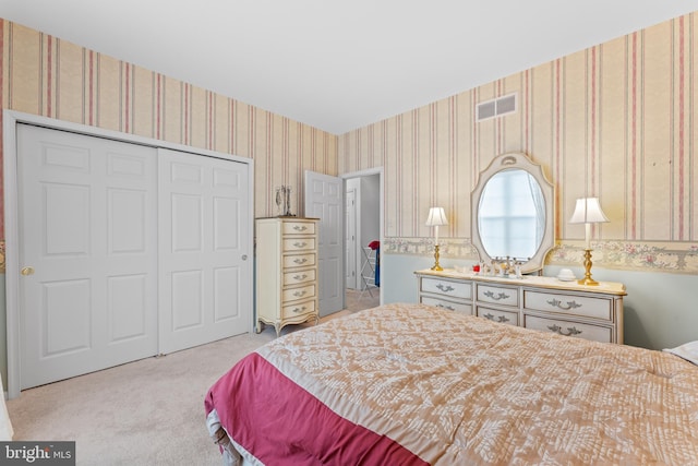 bedroom with wallpapered walls, carpet, visible vents, and a closet