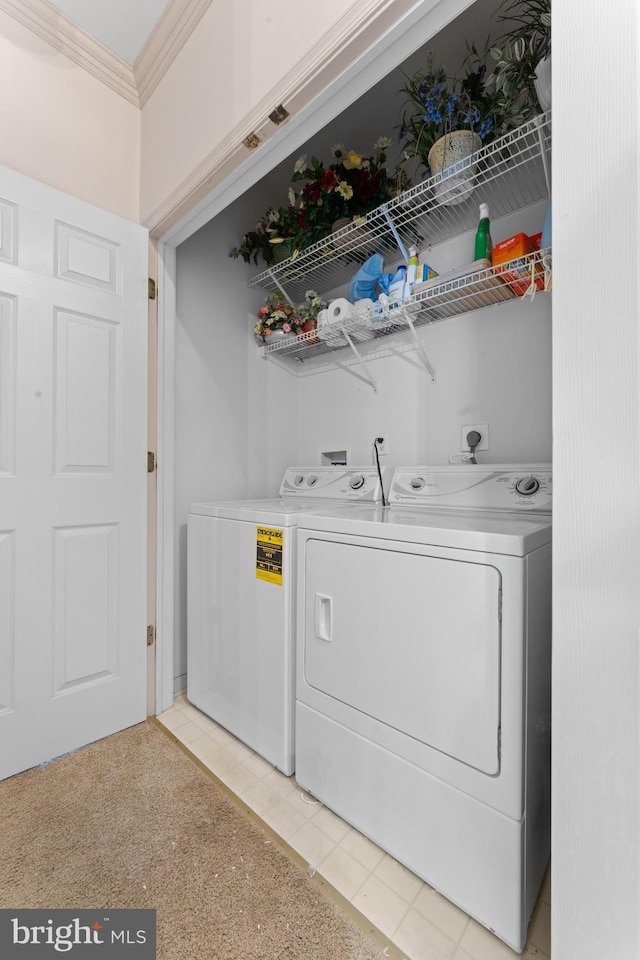 clothes washing area featuring laundry area, washer and clothes dryer, and crown molding