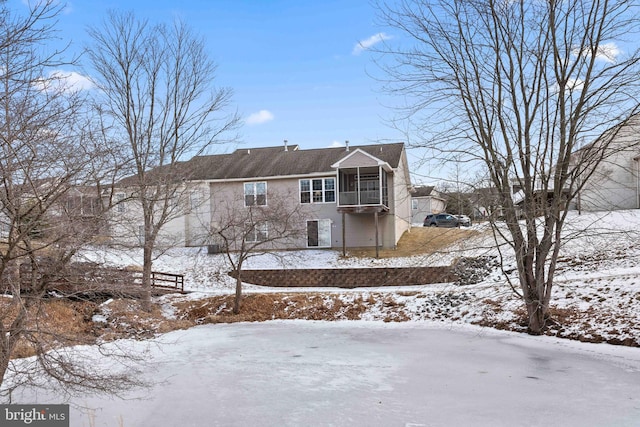 view of snow covered rear of property