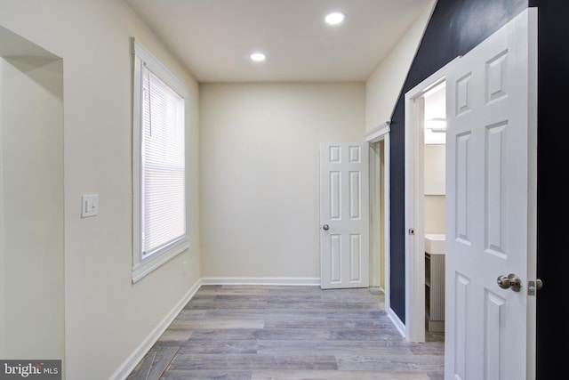 interior space with baseboards, wood finished floors, and recessed lighting