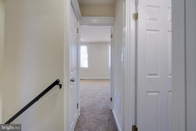 corridor with carpet, an upstairs landing, and baseboards