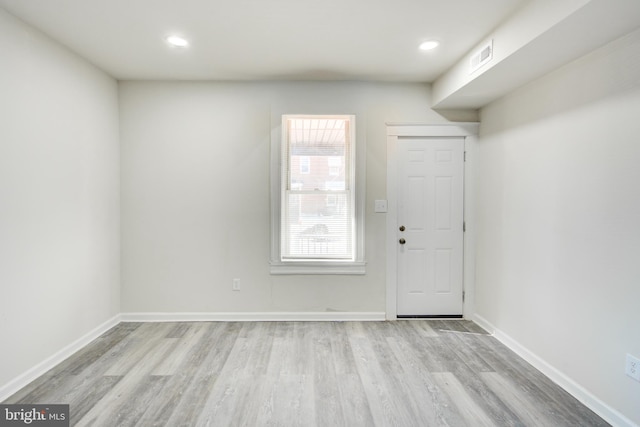 empty room with light wood-type flooring, visible vents, baseboards, and recessed lighting