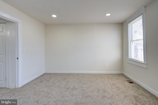 carpeted spare room featuring recessed lighting, visible vents, and baseboards