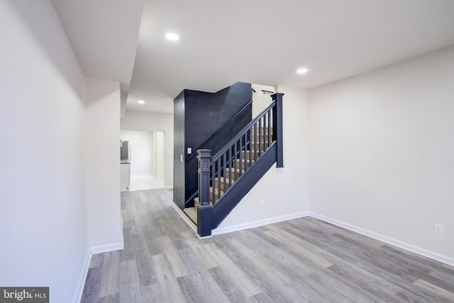 corridor with stairway, recessed lighting, wood finished floors, and baseboards