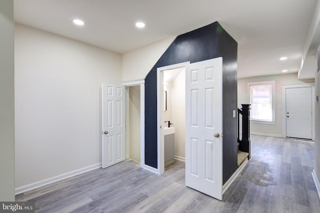 hallway with baseboards, wood finished floors, and recessed lighting