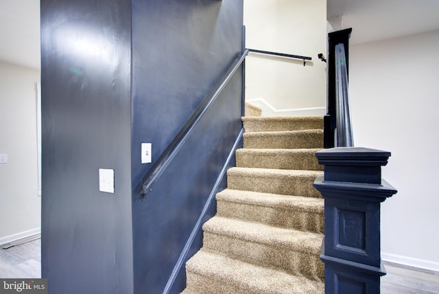 stairway featuring wood finished floors and baseboards