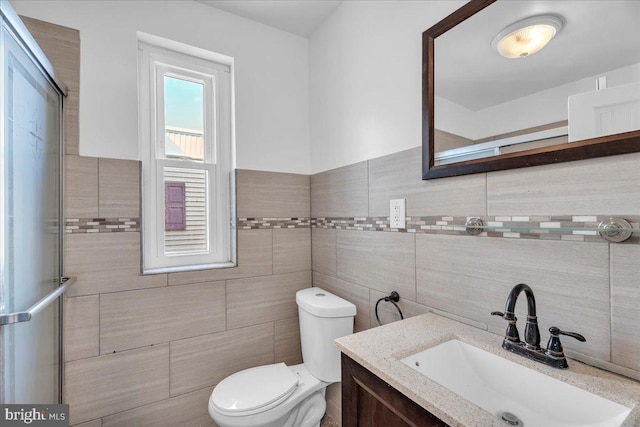 full bath with vanity, toilet, and tile walls