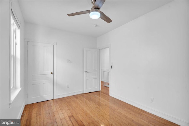 unfurnished bedroom featuring ceiling fan, light wood finished floors, and baseboards