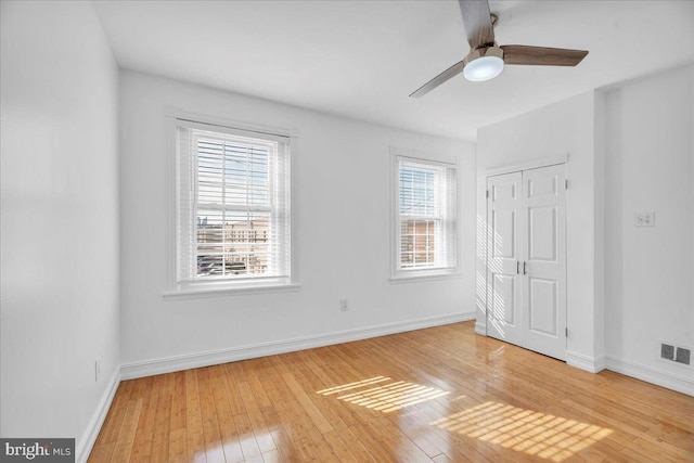 unfurnished bedroom with light wood-type flooring, a closet, and baseboards