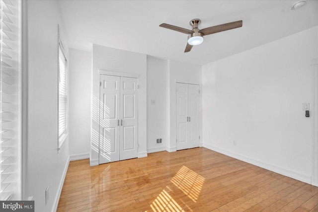 unfurnished bedroom featuring a ceiling fan, light wood-style flooring, and baseboards