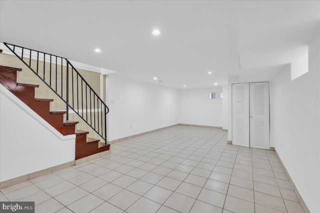 below grade area with light tile patterned flooring, stairway, and recessed lighting