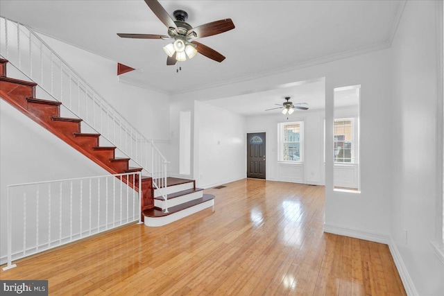 entrance foyer featuring stairs, baseboards, light wood-style flooring, and crown molding