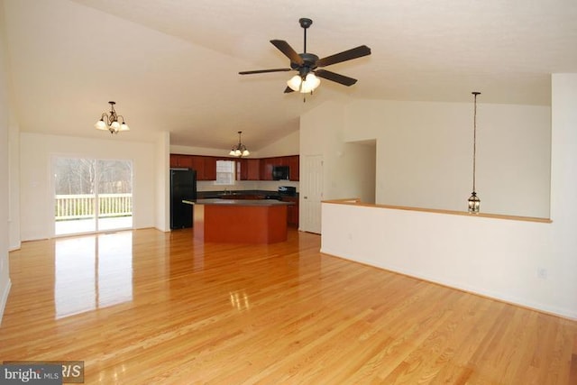 unfurnished living room featuring light wood-type flooring, vaulted ceiling, and ceiling fan with notable chandelier