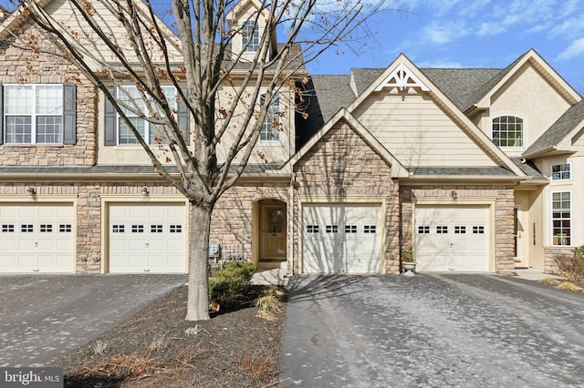 townhome / multi-family property with driveway and a shingled roof