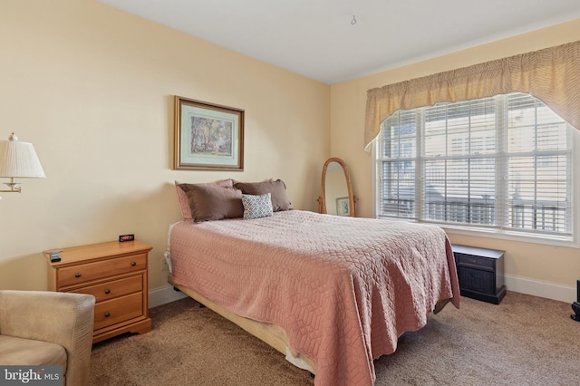 bedroom with multiple windows, baseboards, and carpet flooring