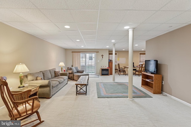 carpeted living area featuring a paneled ceiling, baseboards, and recessed lighting