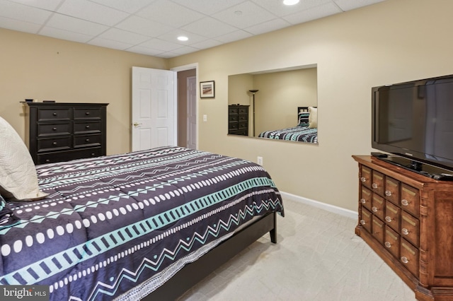 carpeted bedroom with a paneled ceiling and baseboards