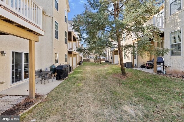 view of yard with a residential view, a patio, and central air condition unit