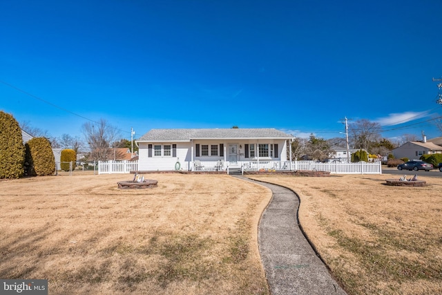 view of front of home with a porch, fence, and a front lawn