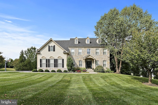 view of front of property featuring stone siding and a front lawn