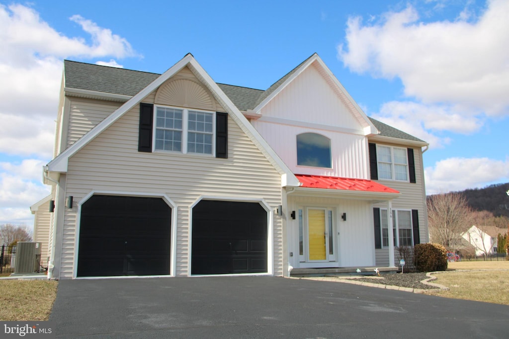 view of front of home featuring a garage, aphalt driveway, and roof with shingles