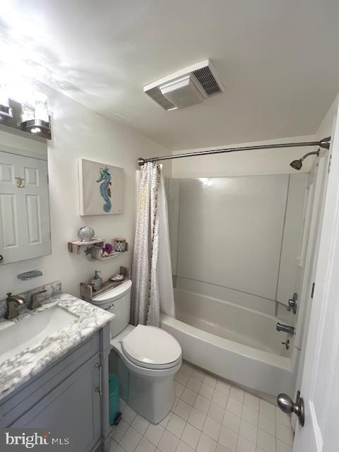 bathroom featuring vanity, shower / bath combo with shower curtain, toilet, and visible vents