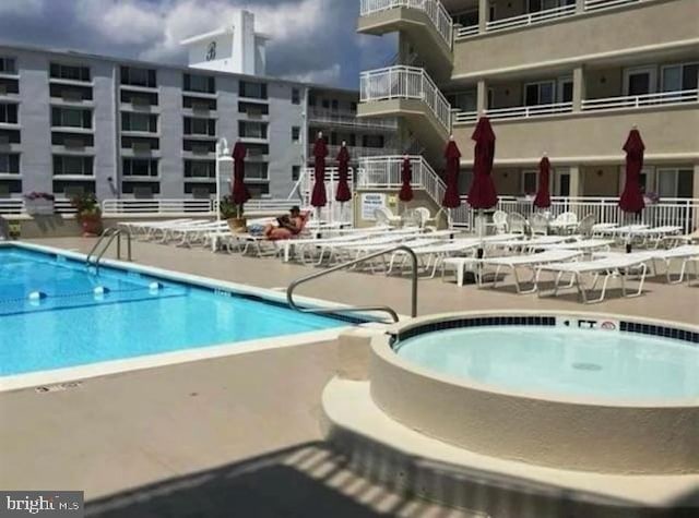 community pool featuring a patio and a hot tub