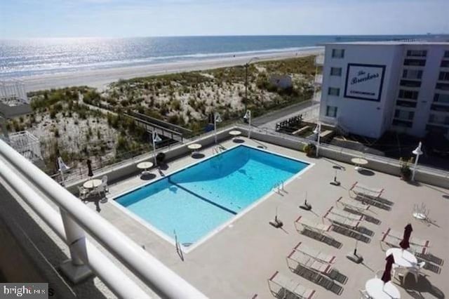 view of swimming pool with a view of the beach and a water view