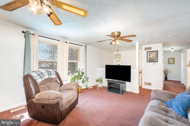 living area featuring carpet flooring, visible vents, and a textured ceiling