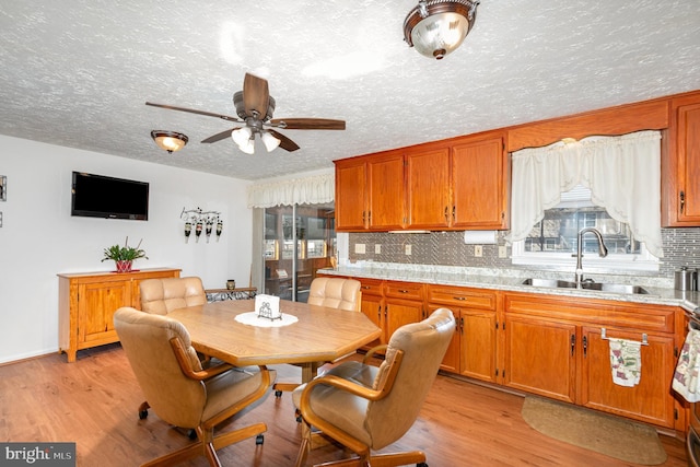 dining room featuring a textured ceiling, light wood-type flooring, and ceiling fan