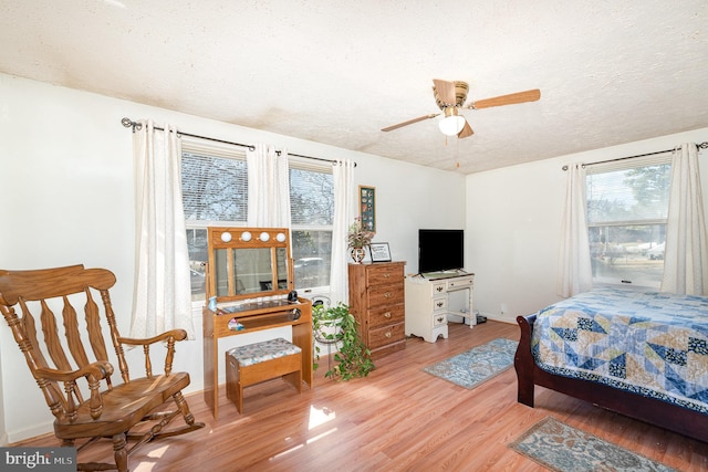 bedroom featuring wood finished floors, baseboards, and a textured ceiling