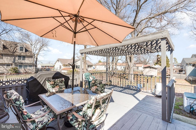 wooden deck with a residential view, outdoor dining area, and fence