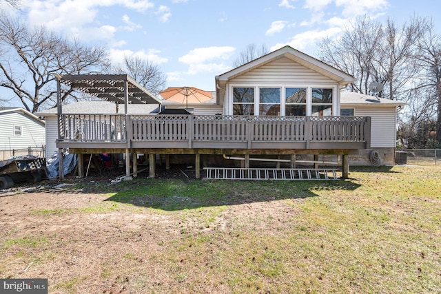 back of property with central air condition unit, fence, a yard, and a deck