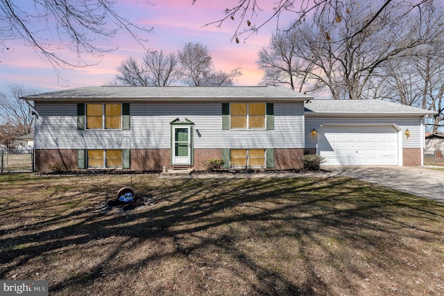 split foyer home with a front yard, fence, entry steps, concrete driveway, and a garage