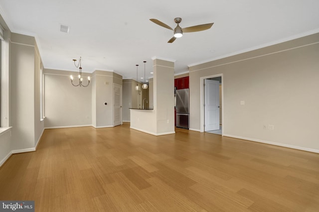 unfurnished living room featuring ornamental molding, a sink, wood finished floors, baseboards, and ceiling fan with notable chandelier