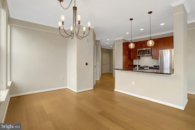 kitchen featuring appliances with stainless steel finishes, dark countertops, light wood-style flooring, and baseboards