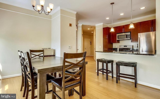 dining room with recessed lighting, light wood-style flooring, ornamental molding, a chandelier, and baseboards