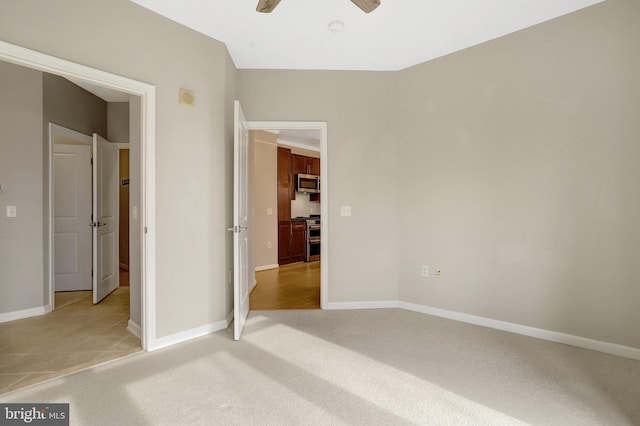 unfurnished bedroom with light carpet, ceiling fan, and baseboards