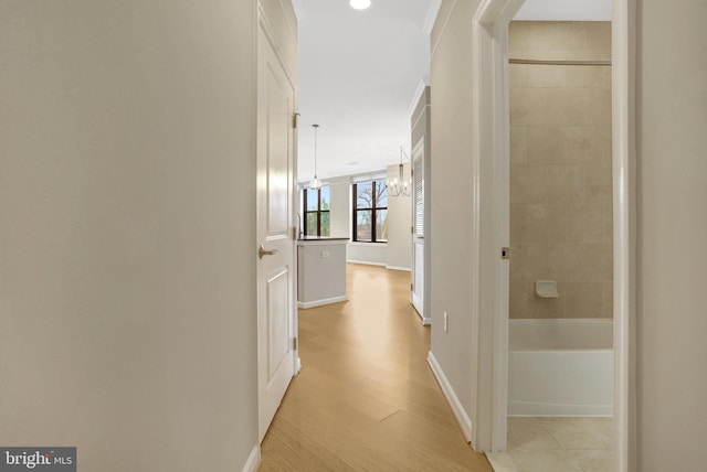 hallway with light wood-style flooring and baseboards