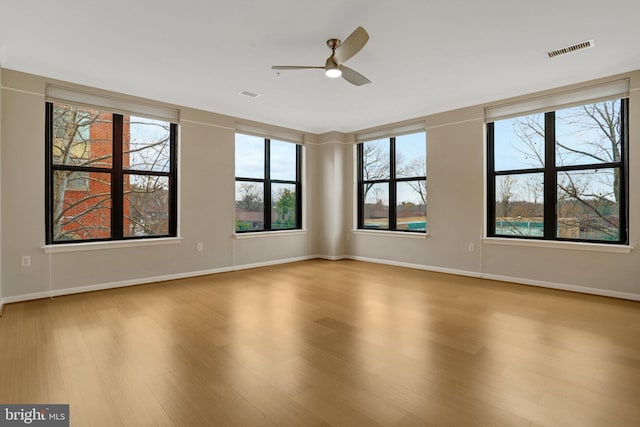 spare room featuring visible vents, baseboards, and wood finished floors