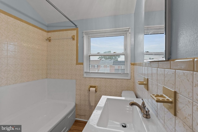 full bathroom featuring a tub, tile walls, and a sink