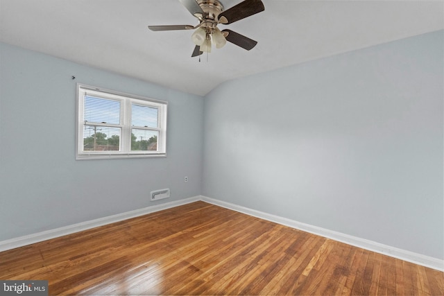 spare room with baseboards, a ceiling fan, wood finished floors, and lofted ceiling
